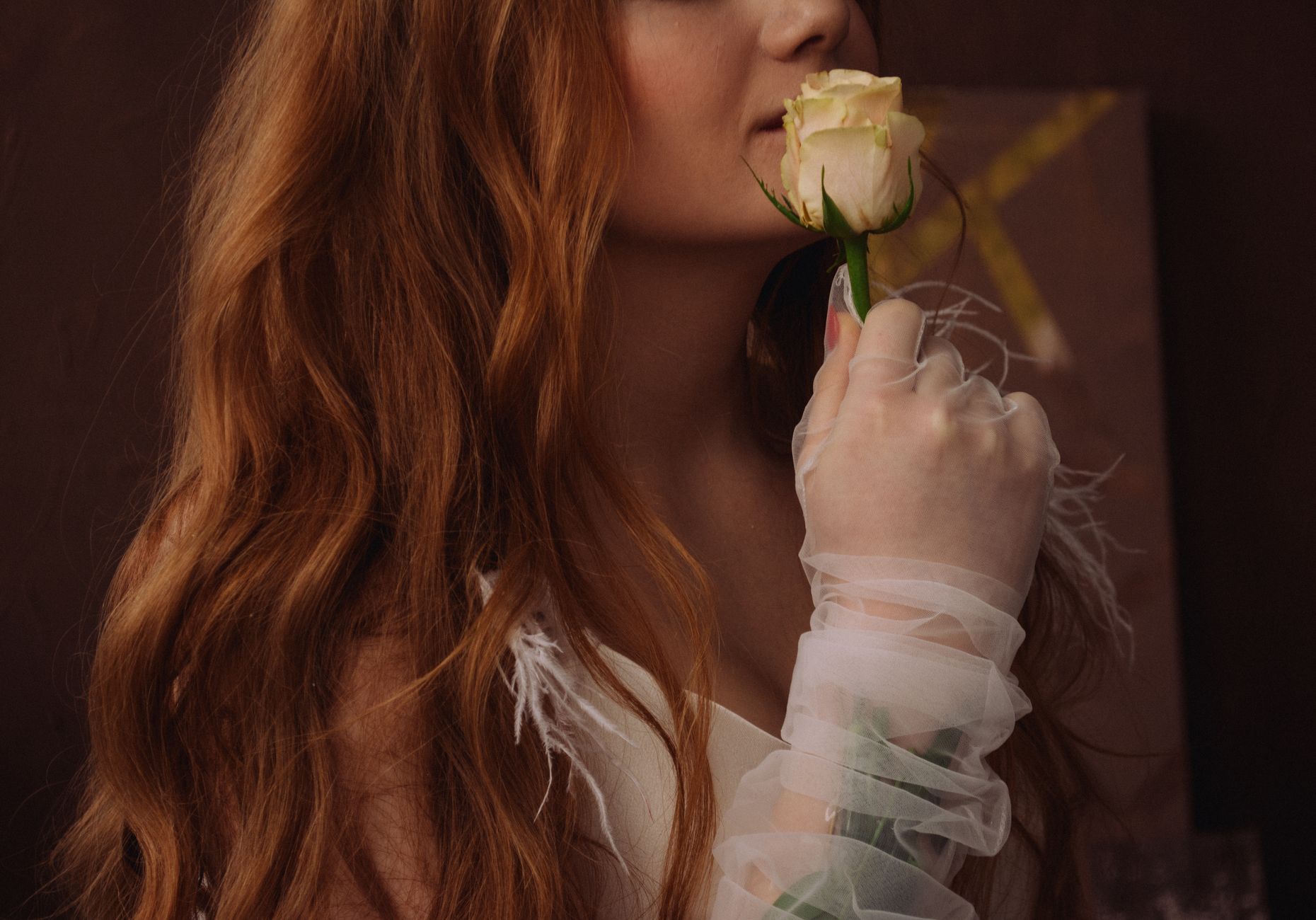 A woman gently holds a white rose, showcasing elegance and beauty with long flowing hair. — BDM Bet Guide