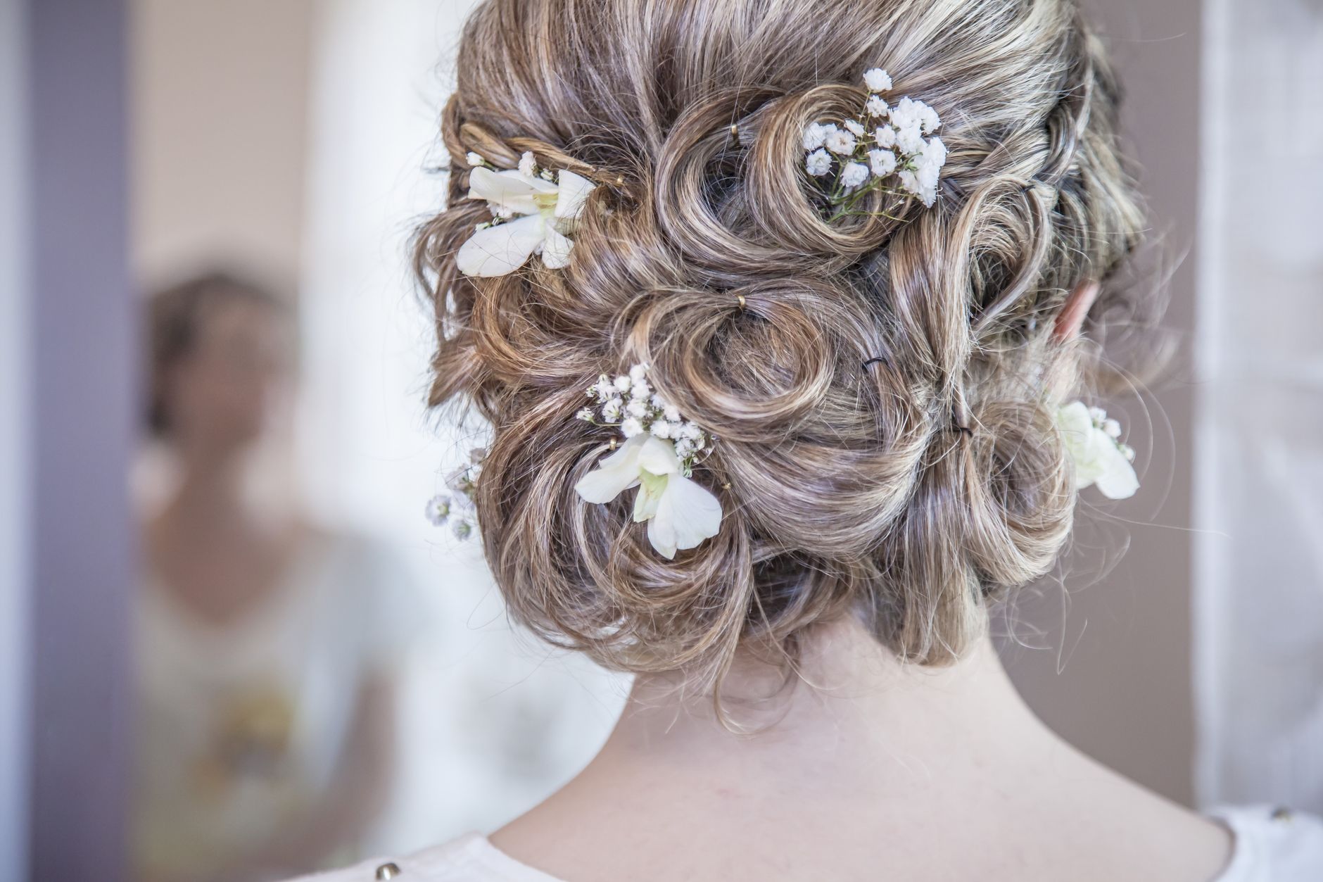 Close-up of an elegant bridal hairstyle featuring delicate white flowers, perfect for a wedding day. — Wanted Dead or a Wild